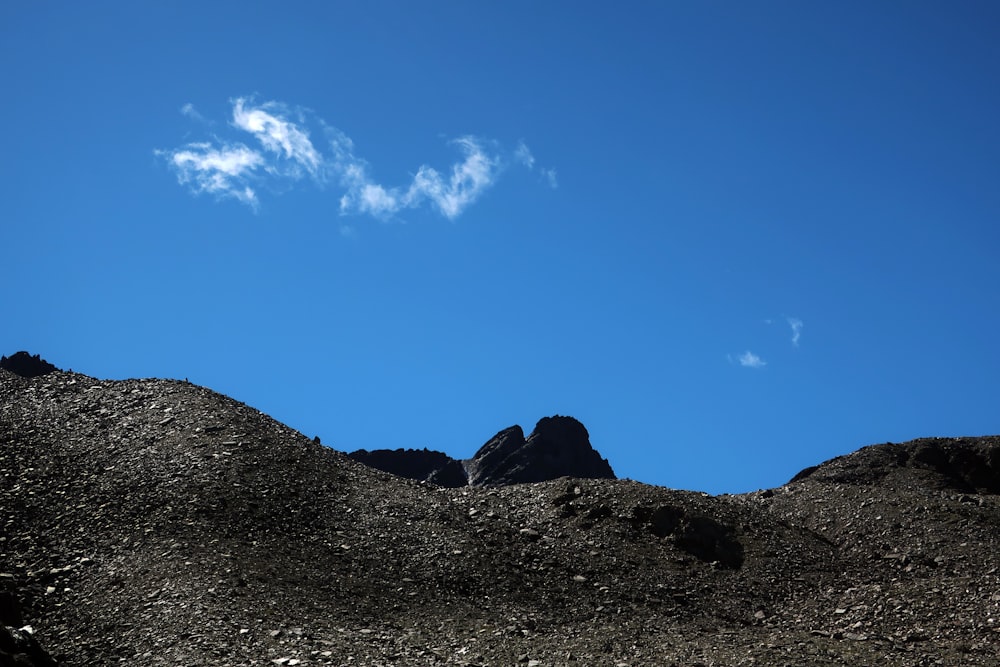 a rocky mountain with a blue sky