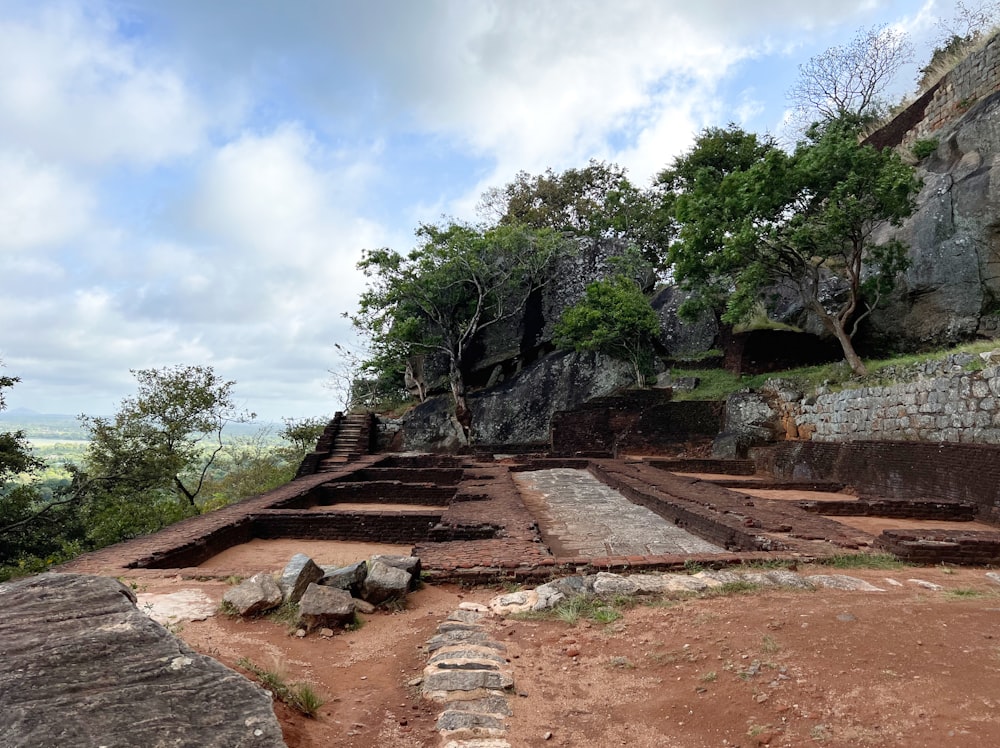 a stone wall with stairs and trees