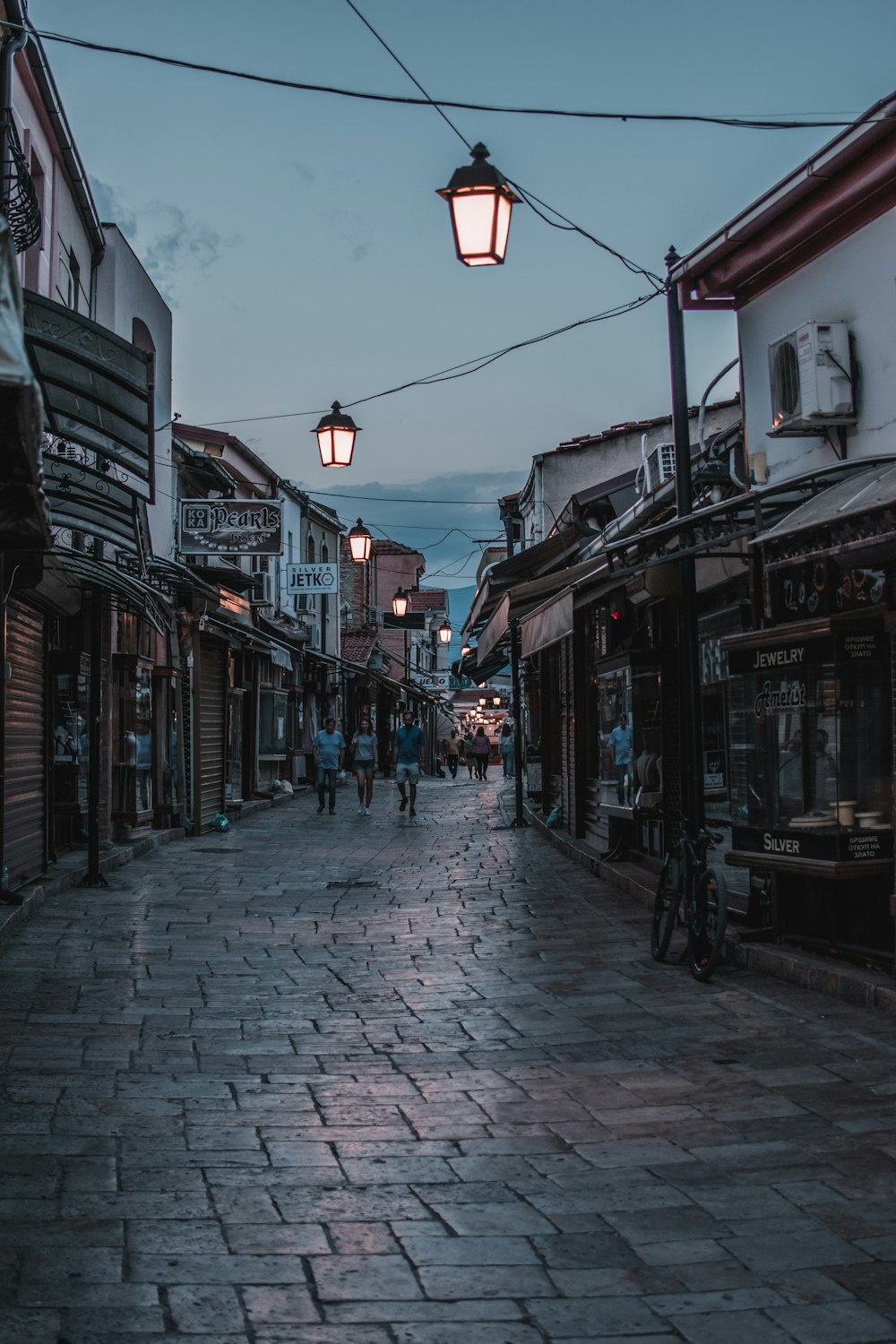 a cobblestone street with people walking on it