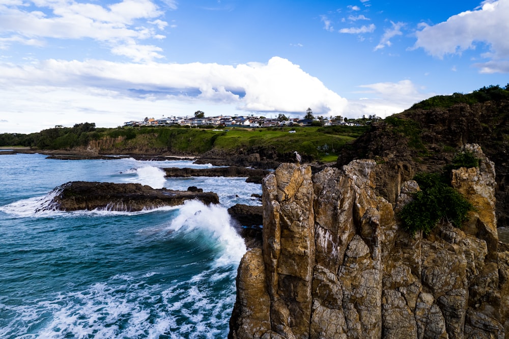 a rocky cliff next to a body of water