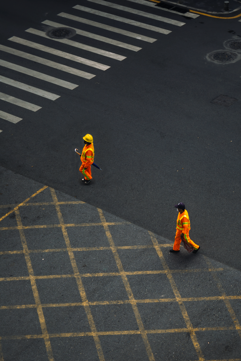 two men in orange suits on a street