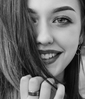 a woman smiling and holding her chin