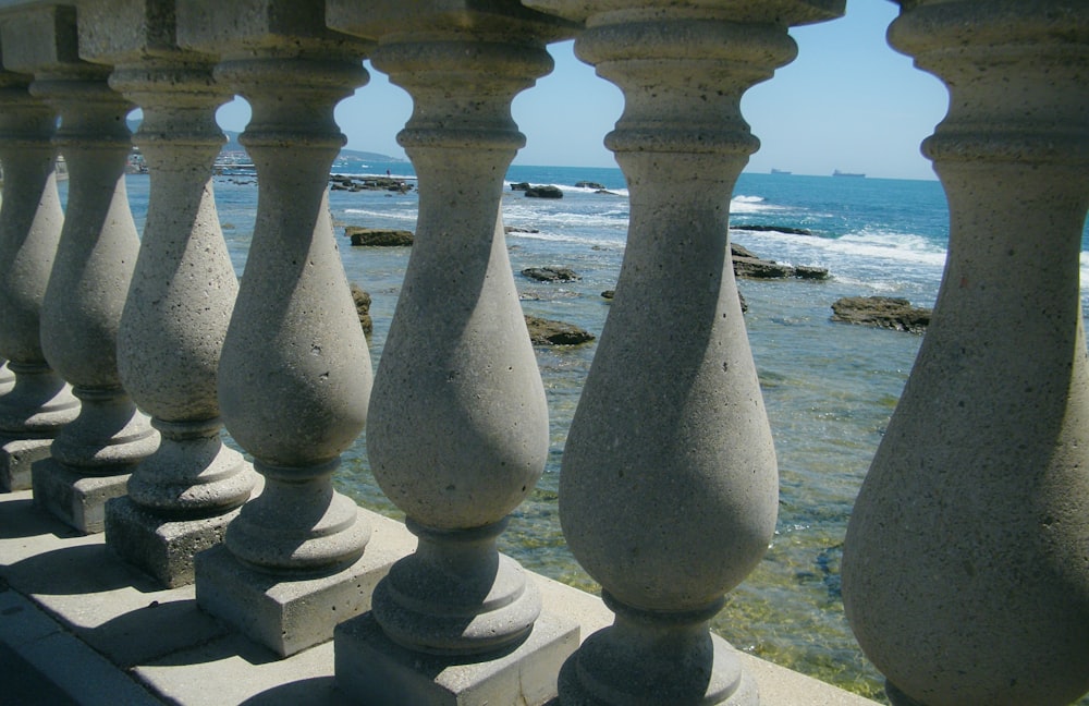 a group of pillars in front of a body of water