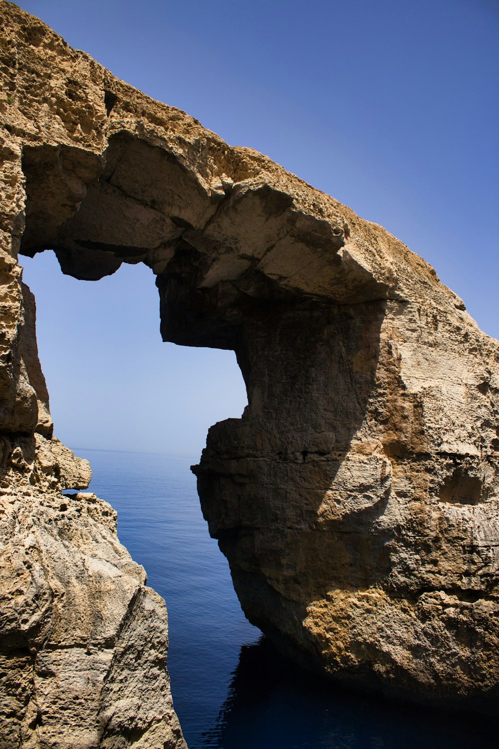 a large rock arch over a body of water