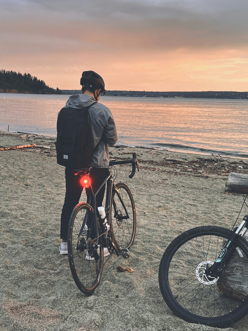 a person standing next to a bike on a beach