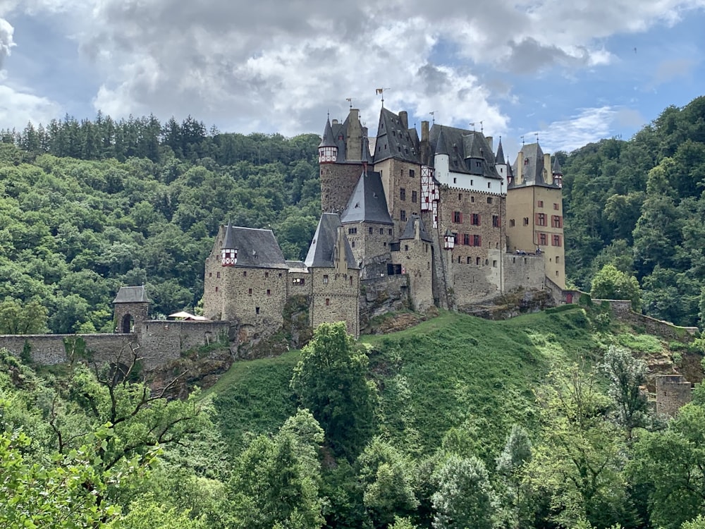 a large castle on a hill with Eltz Castle in the background