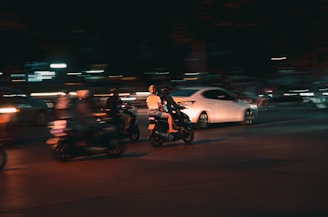 a group of people riding motorcycles at night