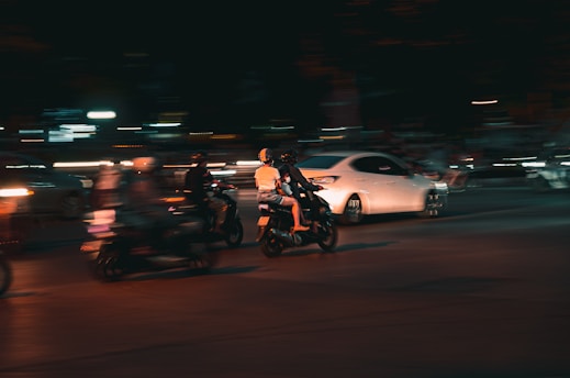 a group of people riding motorcycles at night