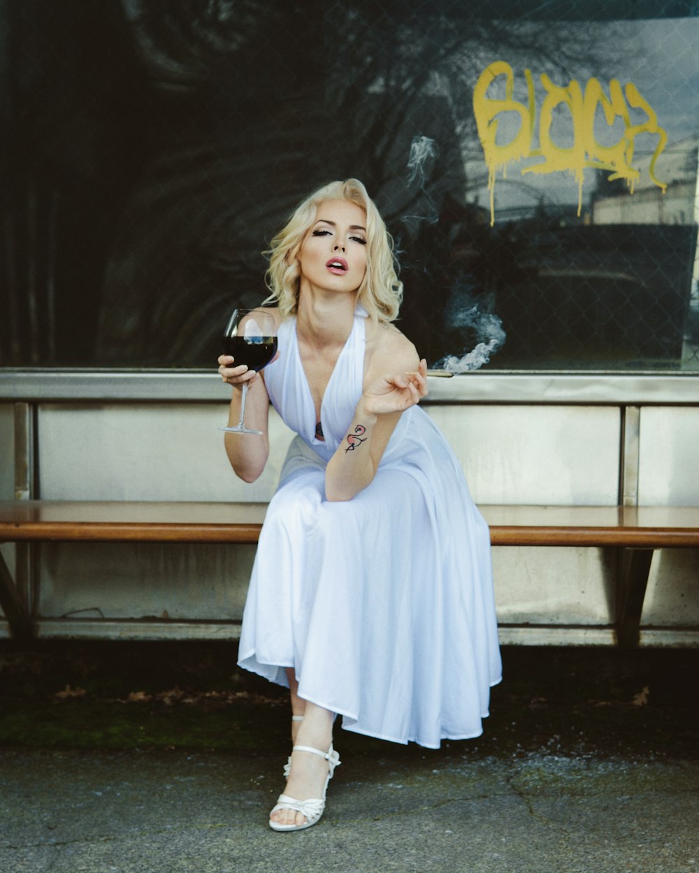 a woman in a dress holding a glass of wine