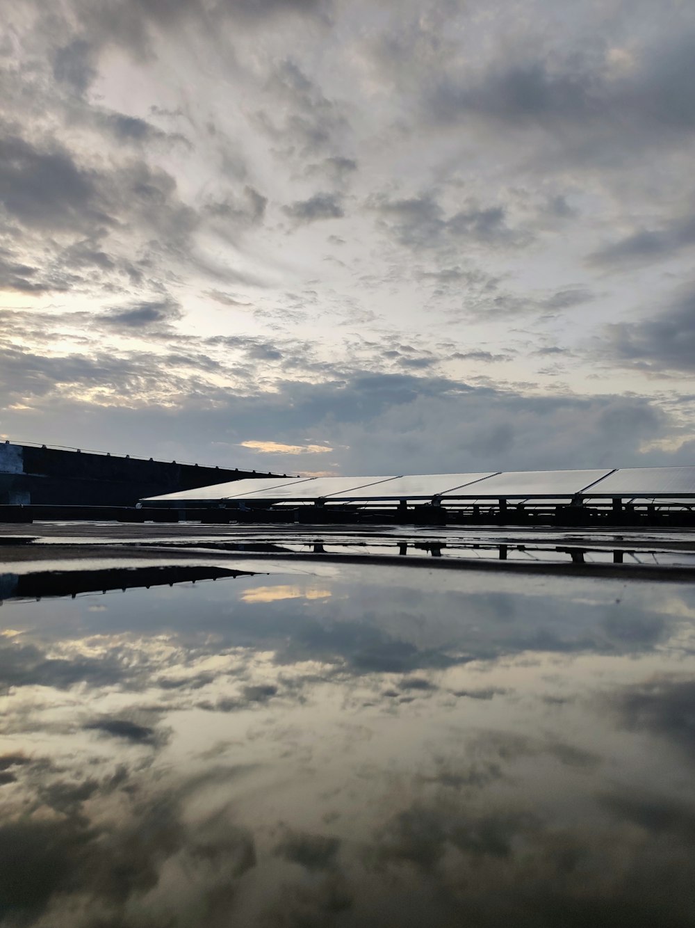 um corpo de água com uma ponte e um céu nublado