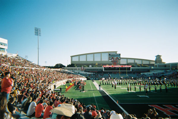 Football stadium filled with crowd under lights