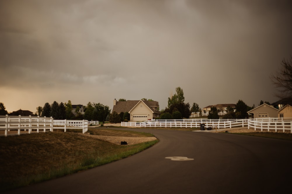 a road with white fences and houses