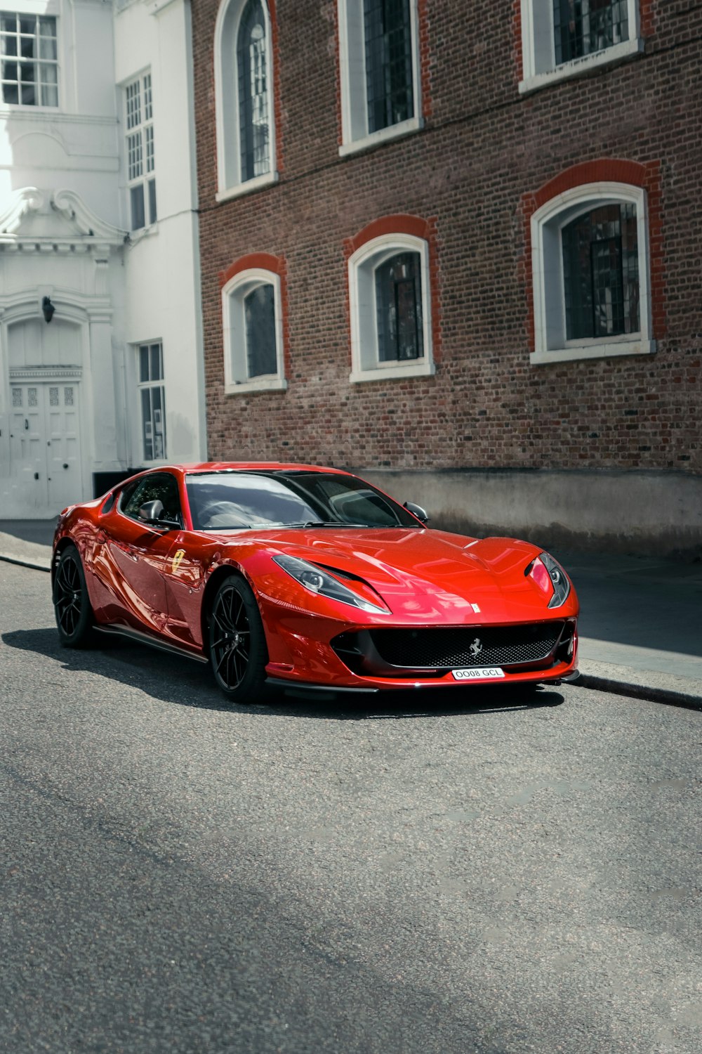 a red sports car parked in front of a brick building