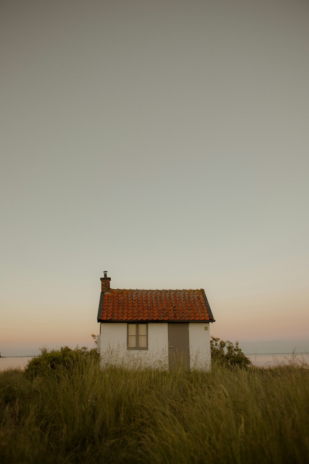 a small white house in a grassy field