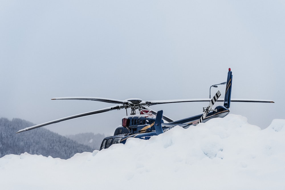 a helicopter flying over snow