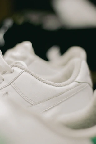 A close-up shot of a pair of gently worn sneakers with visible quality stitching and clean soles.