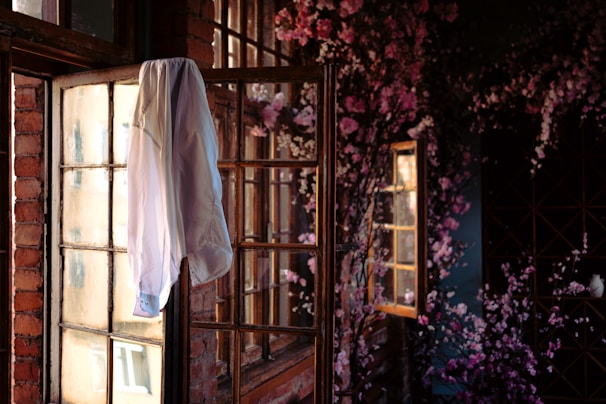 A vibrant floral blouse with puffed sleeves laid out on a rustic table with natural light.