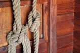 An elegant rope tied in a decorative knot on a rustic wooden table.