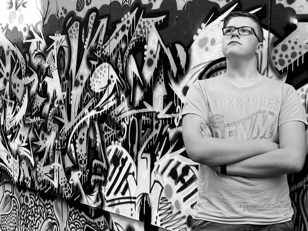 a person standing in front of a wall covered in graffiti