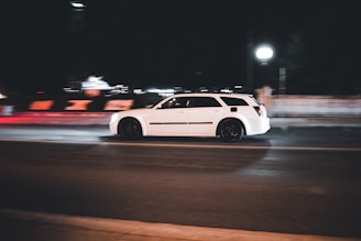 a white car on a road at night