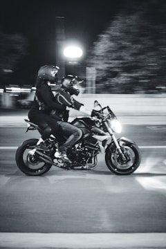 a couple of people ride a motorcycle