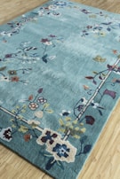 A one-of-a-kind commissioned rug with a whimsical floral design spread across a hardwood floor.