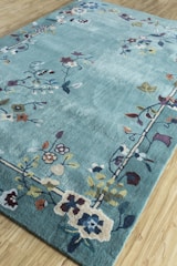 Soft hand-tufted rug with a modern floral pattern laid out in a cozy living room.