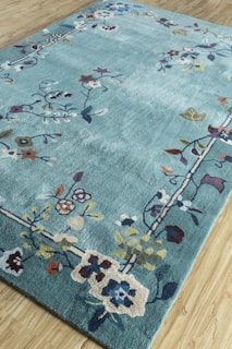 A one-of-a-kind commissioned rug with a whimsical floral design spread across a hardwood floor.