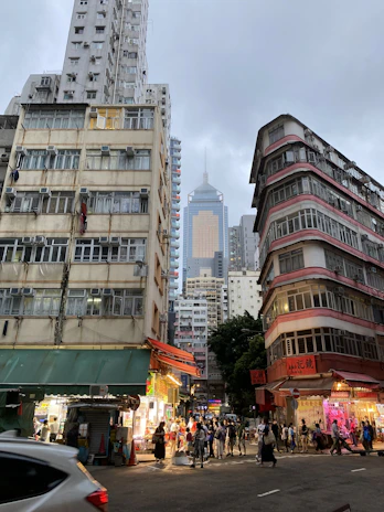 A bustling mixed-use development with retail shops on the ground floor and apartments above.