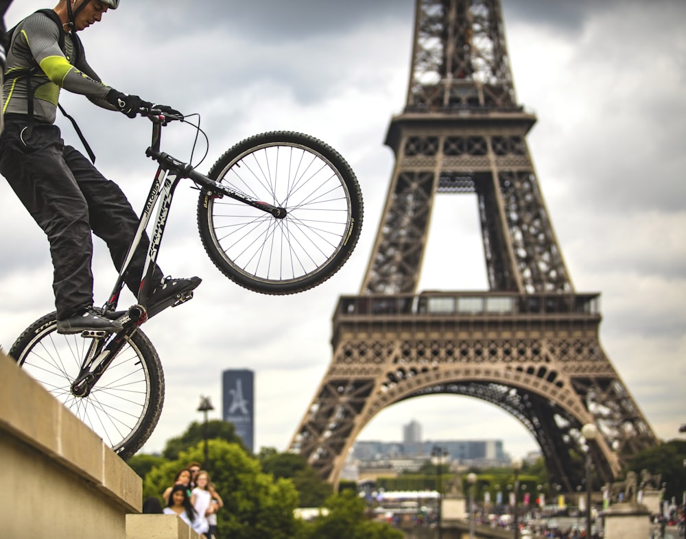 a man on a bike in front of the eiffel tower