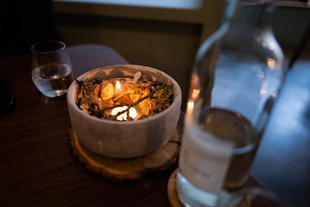 a bowl of food and a glass of water on a table