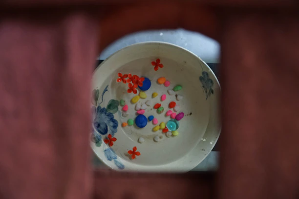 Close-up of a bright, multicolored decorative bowl on a wooden table.