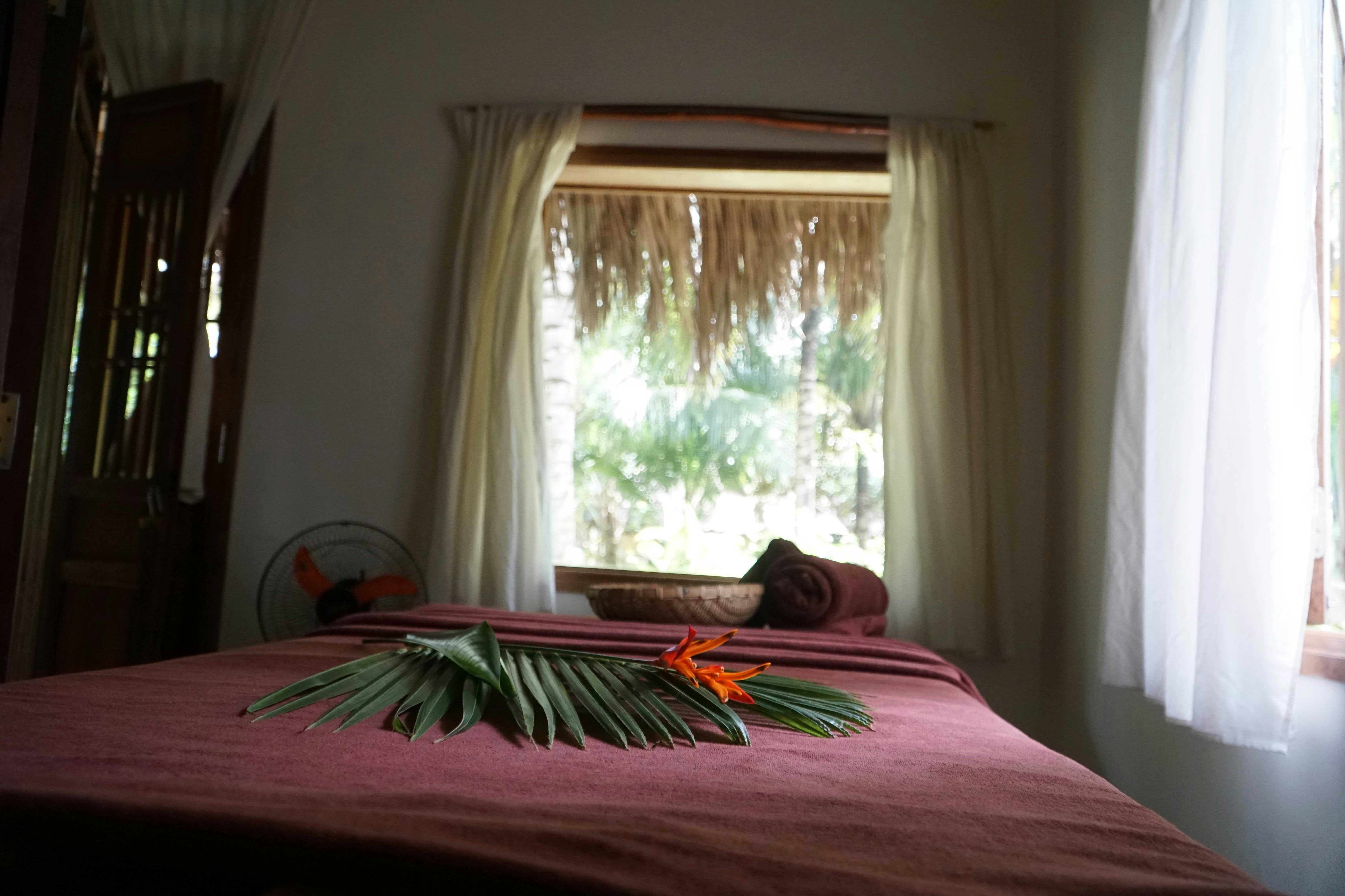 tempat tidur dengan selimut merah dan jendela dengan tirai