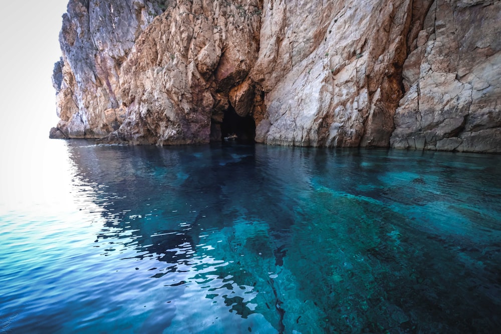 un cuerpo de agua con una cueva en el costado