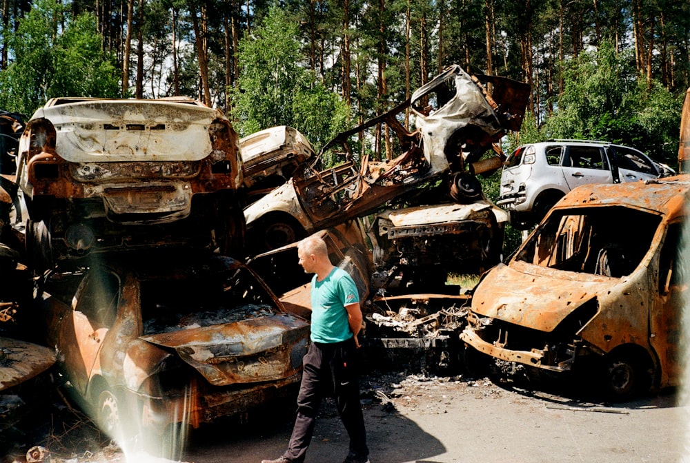 a person standing next to a destroyed car