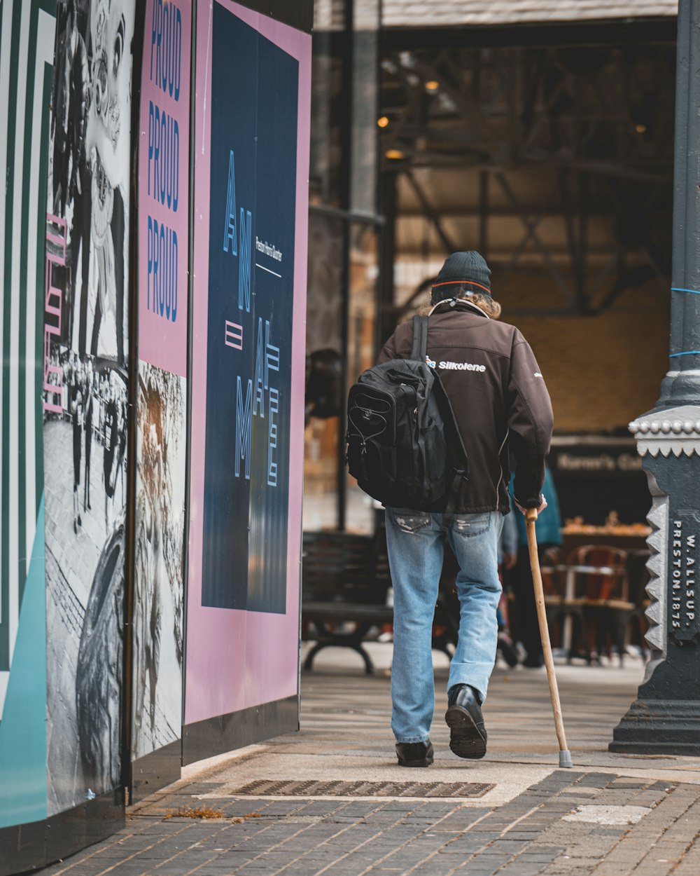 a person with a backpack walking down a sidewalk