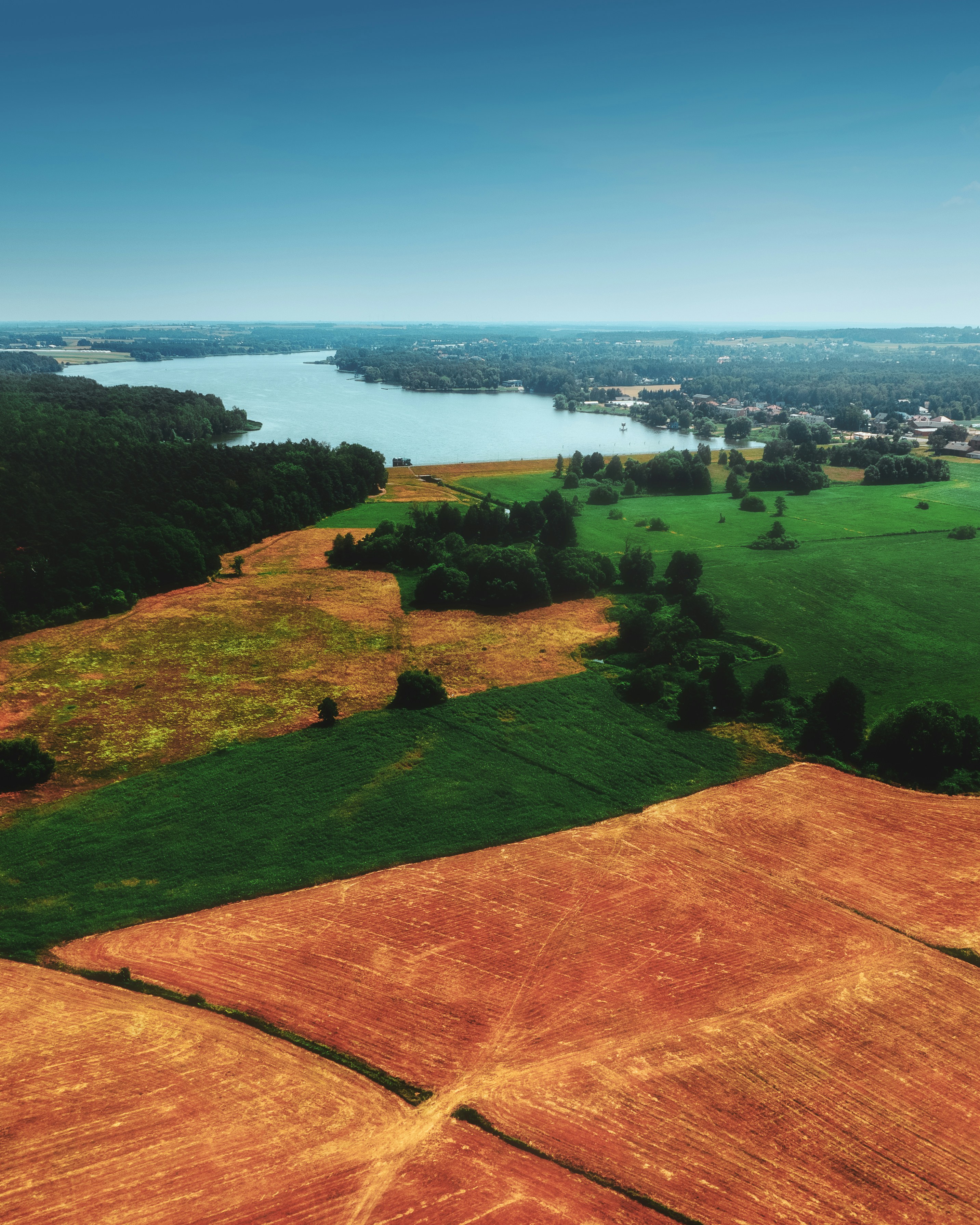 a green field with a body of water in the background