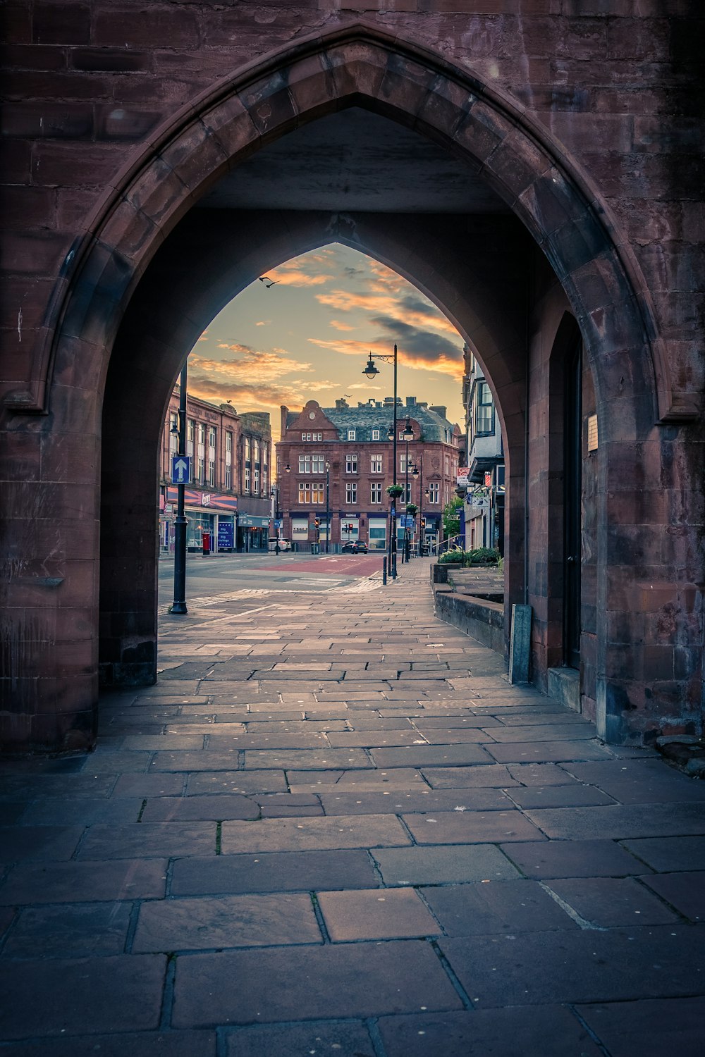 a stone walkway with buildings in the background