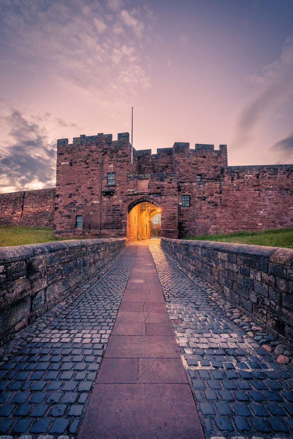 a brick walkway leading to a castle