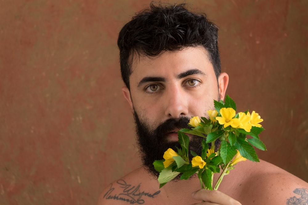 a man with a beard holding flowers