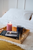 A cozy corner with soft cushions, a candle, and a motivational book.