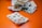 A collection of various blister packs containing different types of tablets and capsules are spread out on an orange surface. The blister packs are partially empty, with some tablets missing.
