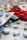 Various blister packs containing pills are displayed, featuring different colors such as white, green, blue, and red. The image focuses on the texture and layout of the blister packs scattered around.