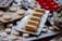 A close-up view of various pills and capsules in blister packs, including brown capsules and white round tablets. The blister packs are arranged haphazardly, with some lying flat and others overlapping. The lighting highlights the shiny surface of the packaging, creating reflections.