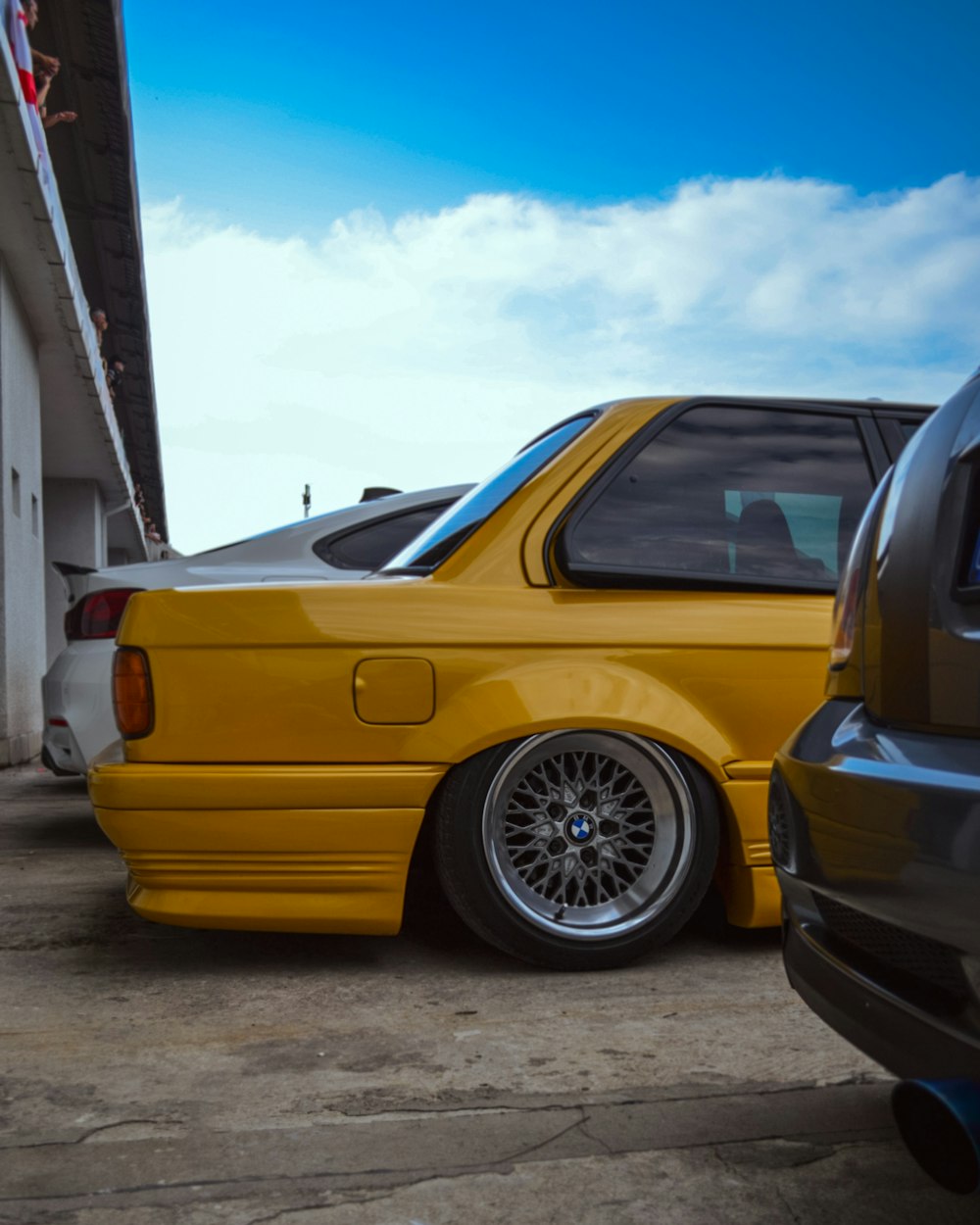 a yellow car parked next to another car