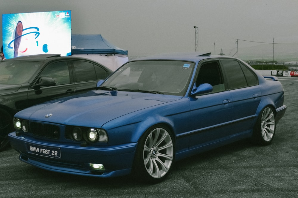 a blue car parked next to a black car