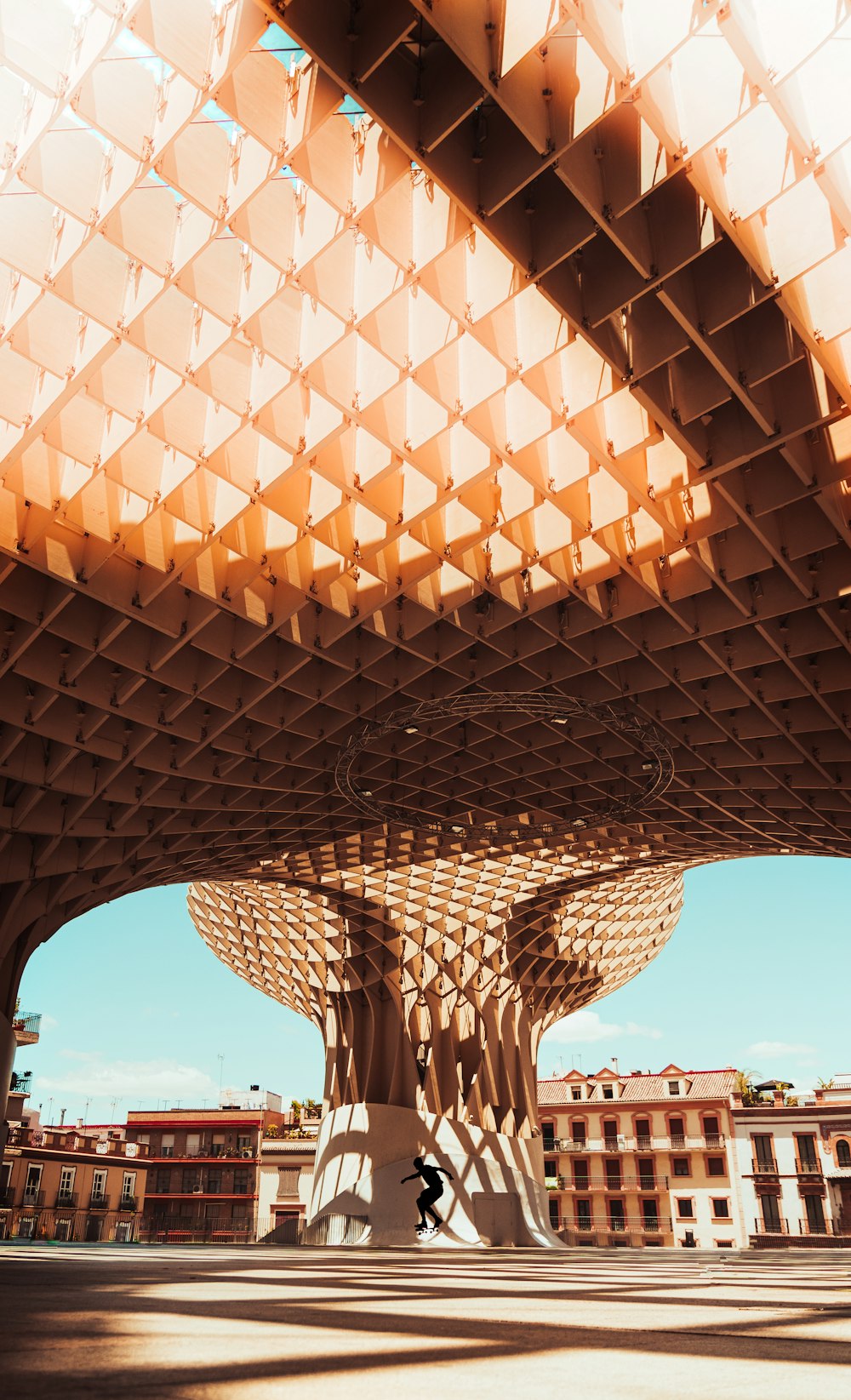 a large circular structure with a person walking underneath it