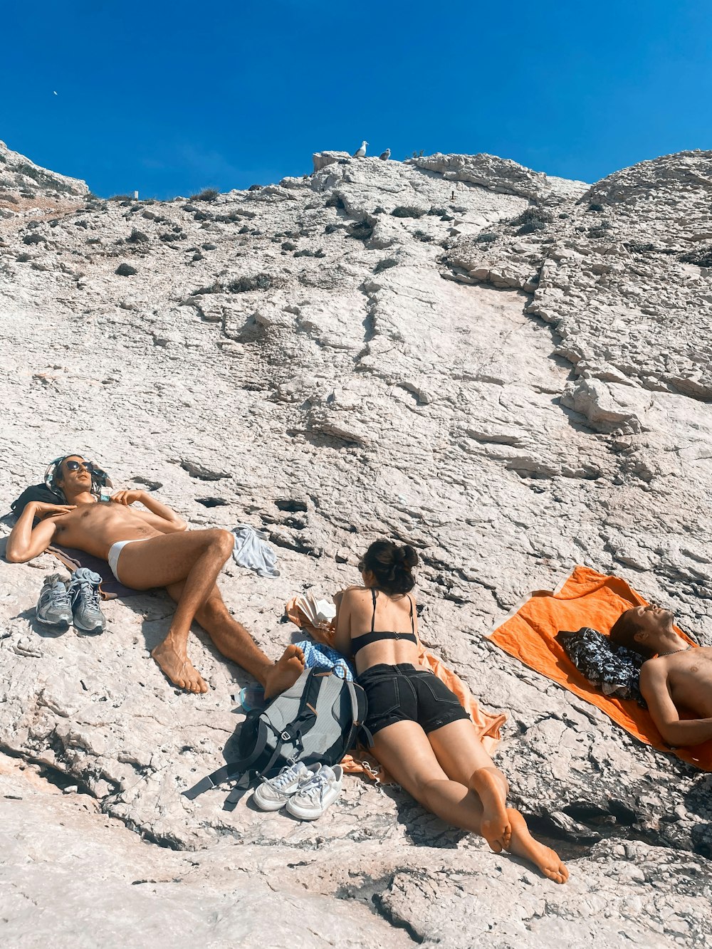 a group of people lying on a rocky beach