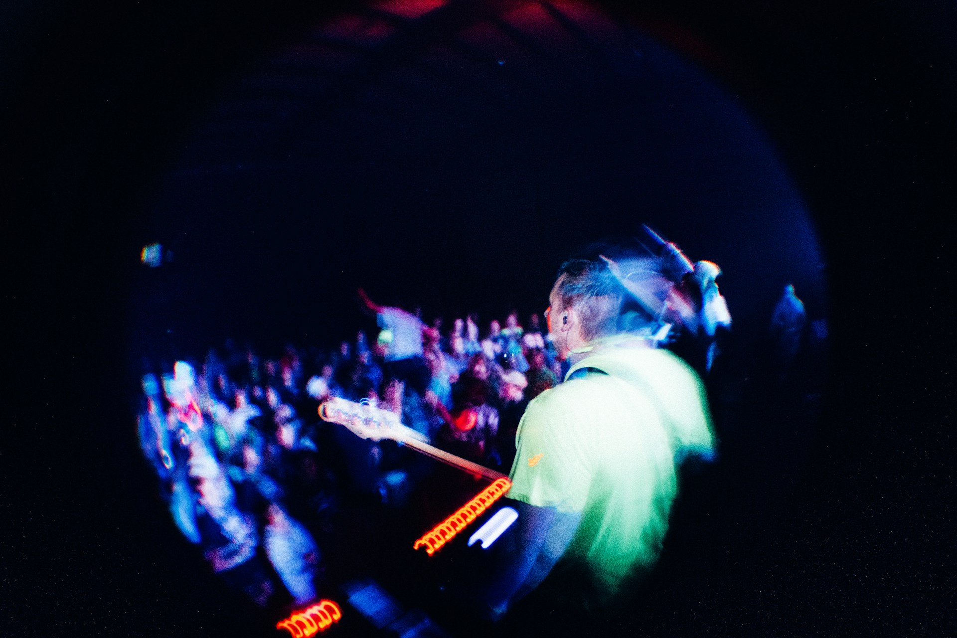Dynamic wide-angle photo capturing Shaan Frenƶy in action with his drum kit, surrounded by a roaring crowd.