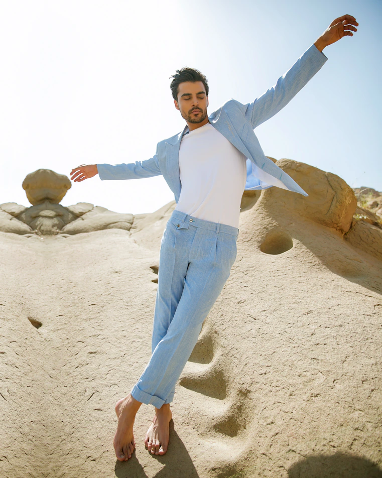 a man in a white shirt and jeans jumping in the air